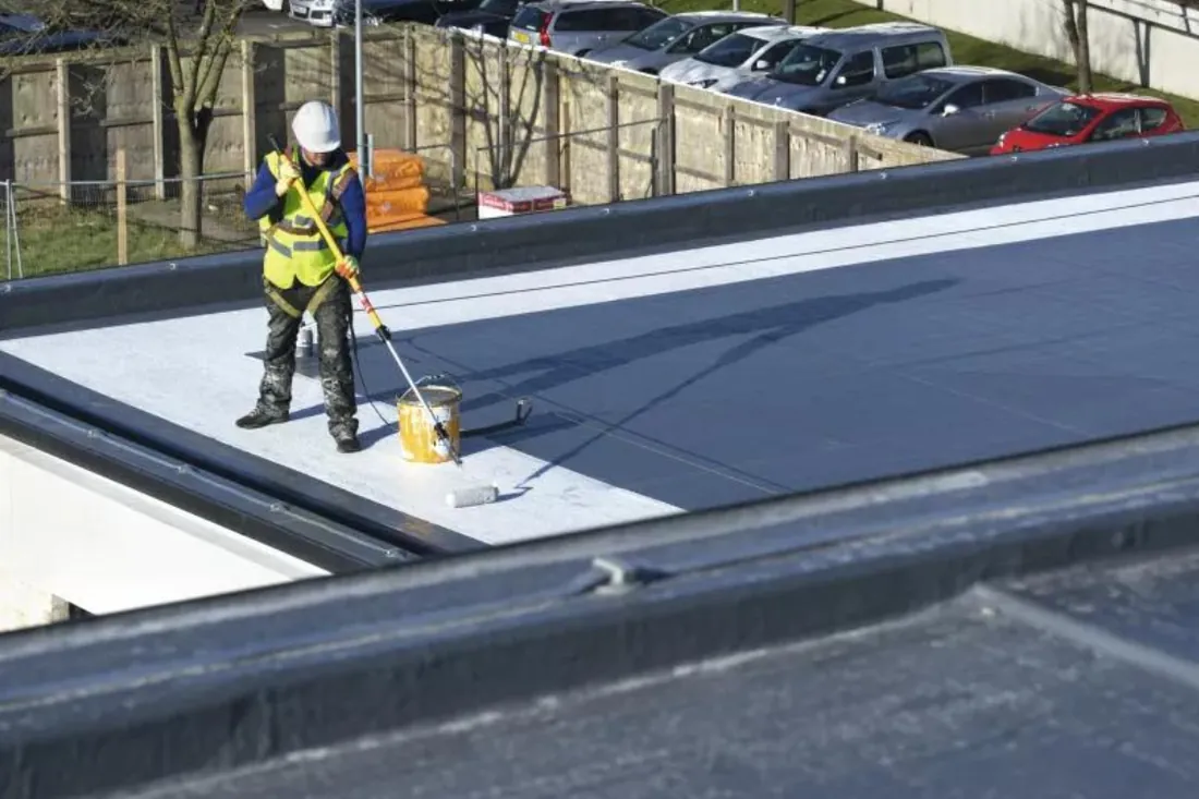 Étancheur équipé travaillant sur une toiture-terrasse