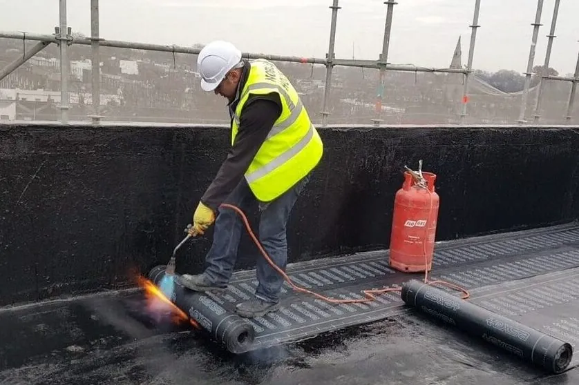 Soudure au chalumeau d'une membrane bitumineuse sur une toiture-terrasse