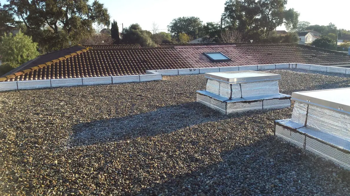 Toiture-terrasse protégée par gravillons roulés, avec lanterneaux